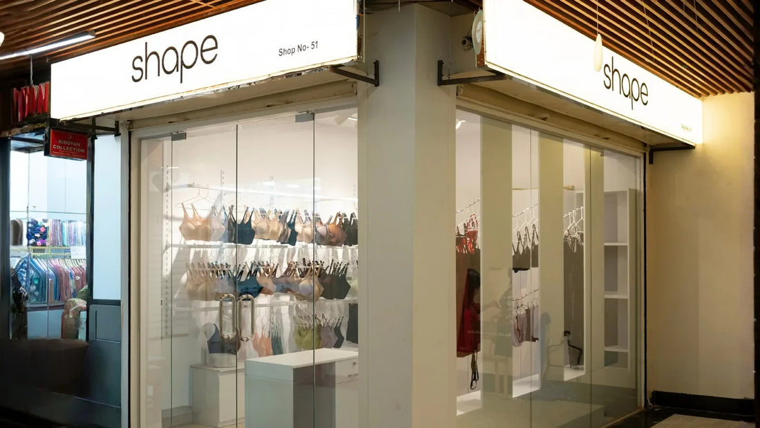 Interior of SHAPE Lingerie Banani with lounge seating, bra racks and packaged basics on shelves